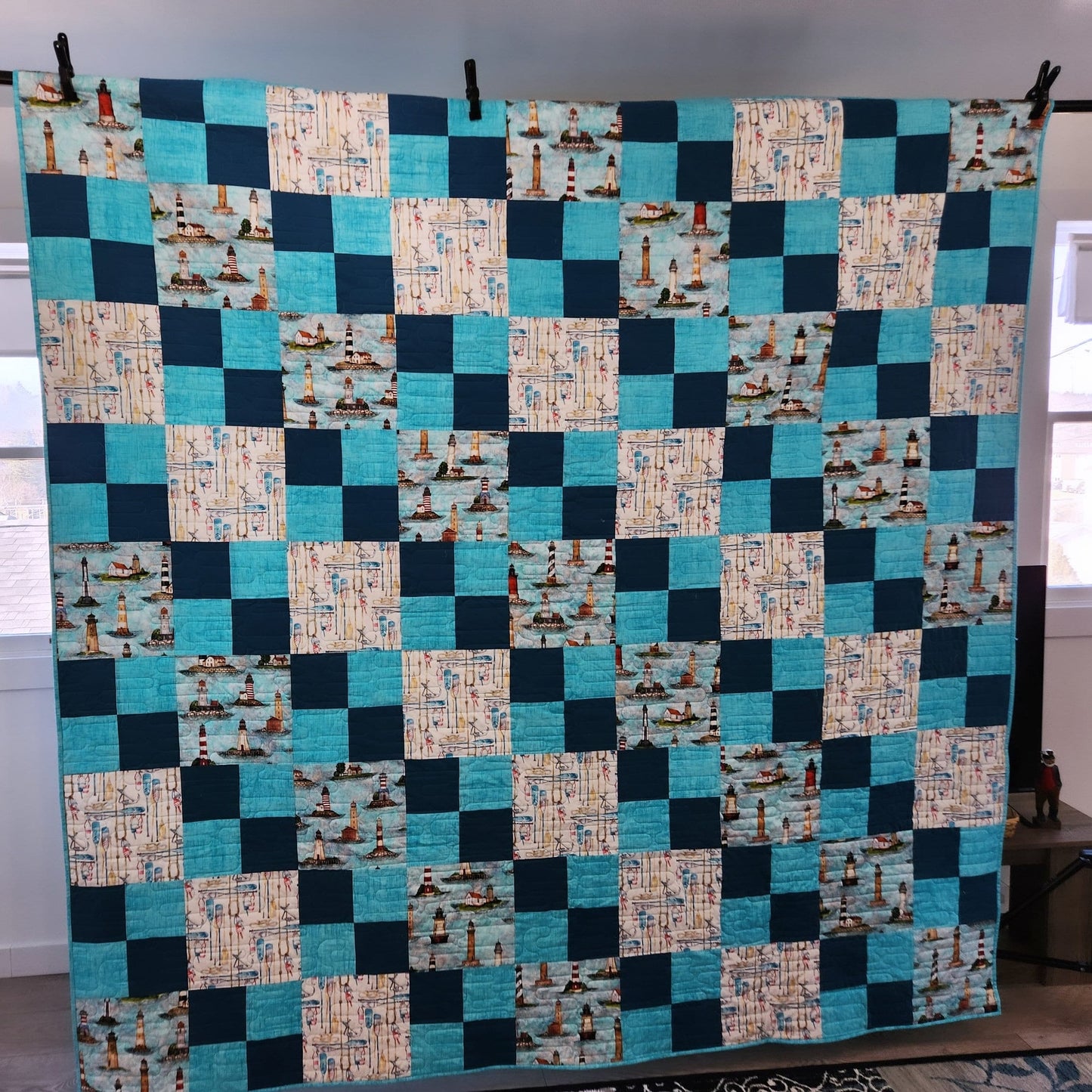 Seaside dreams handmade quilt with lighthouses buoys oars and ropes 87" x 87". This cute teal quilt is coastal marine atmosphere.