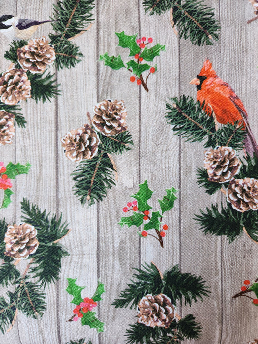 Christmas fabric.  Wood plank background with Cardinals, chickadees, holly, and pinecones