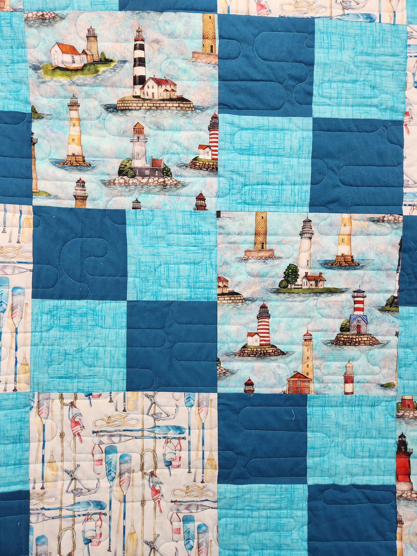 Seaside dreams handmade quilt with lighthouses buoys oars and ropes 87" x 87".  This cute teal quilt is coastal marine atmosphere.